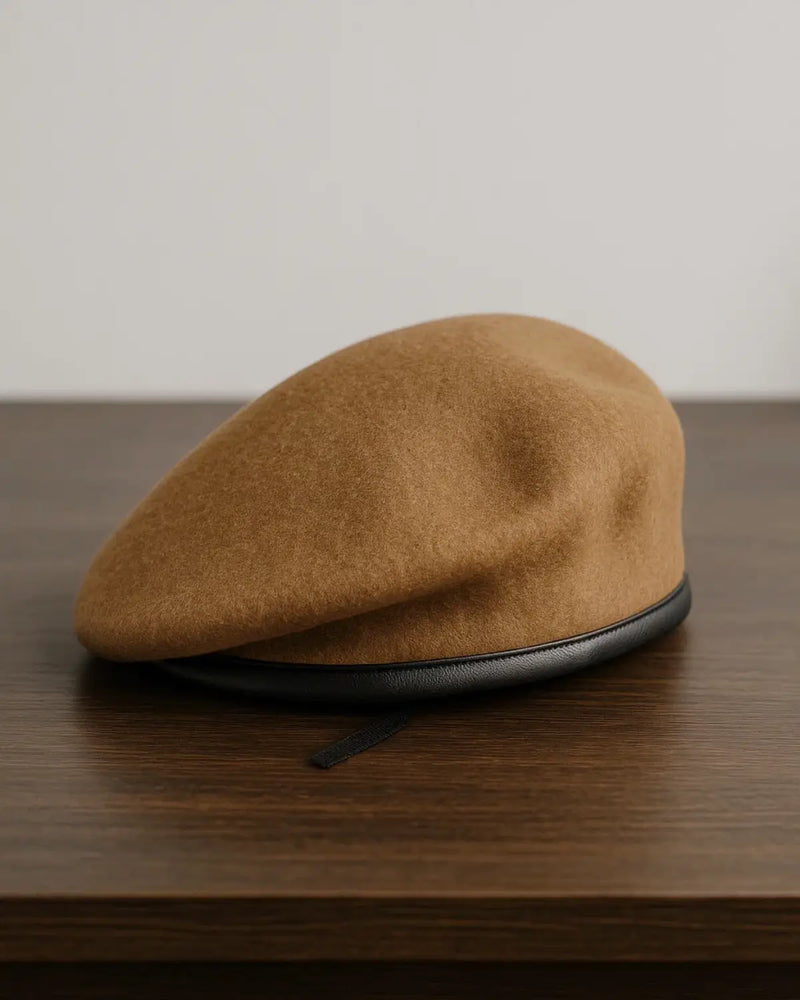 Boina Masculina Francesa Lã Ajustável Brown posicionada sobre mesa de madeira escura, destaque para o design arredondado e sofisticado.