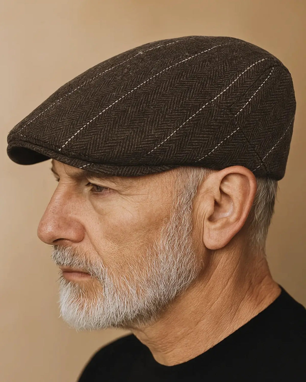 Close lateral da boina masculina inglesa de algodão marrom, destacando costuras e padrão em espinha de peixe.