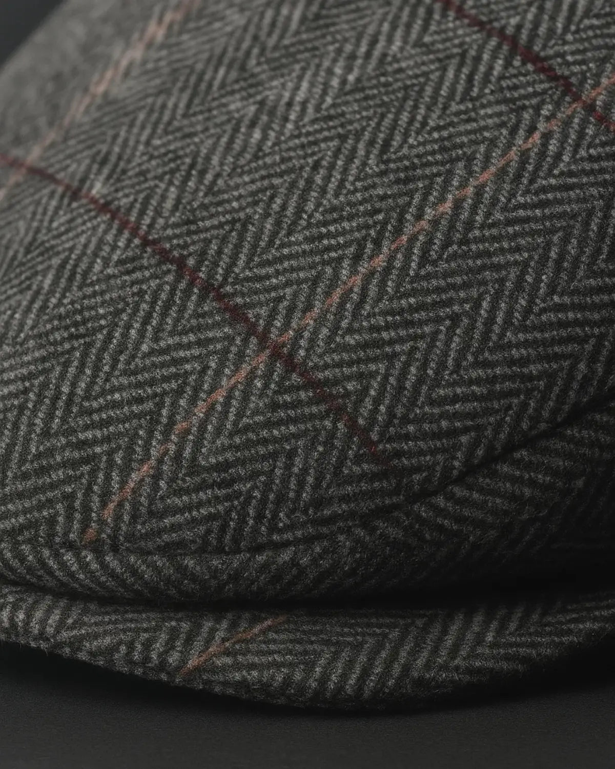 Close detalhado da boina masculina inglesa cinza com padrão quadriculado e textura de alta qualidade.