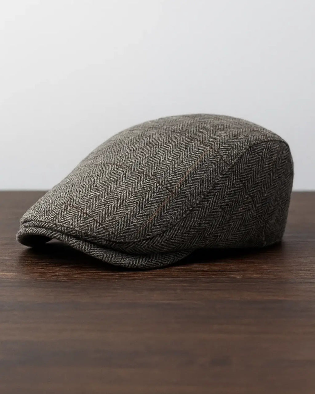 Boina inglesa masculina cinza sobre fundo neutro, mostrando design clássico e sofisticado.