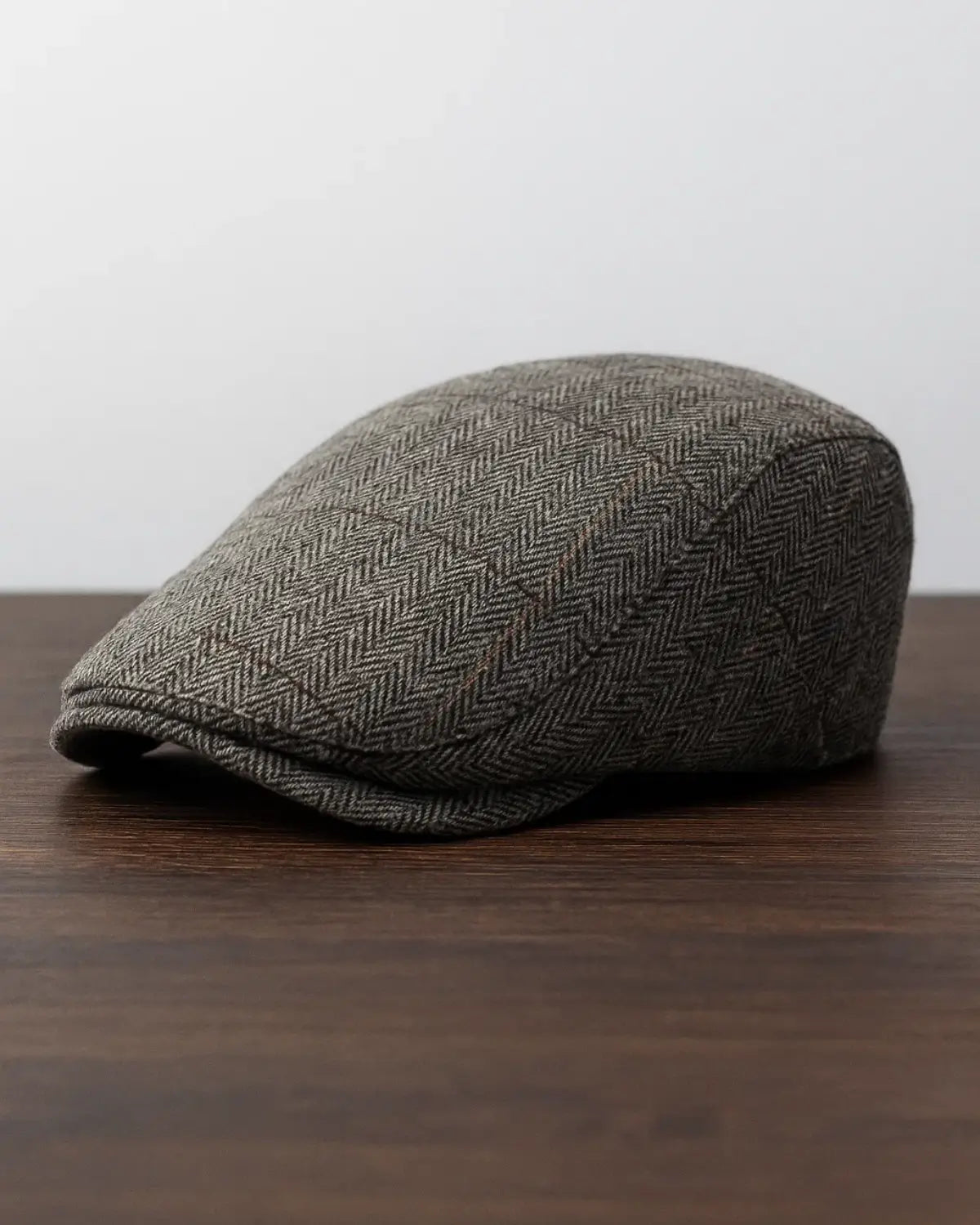 Boina inglesa masculina cinza sobre fundo neutro, mostrando design clássico e sofisticado.