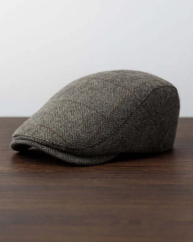 Boina inglesa masculina cinza sobre fundo neutro, mostrando design clássico e sofisticado.