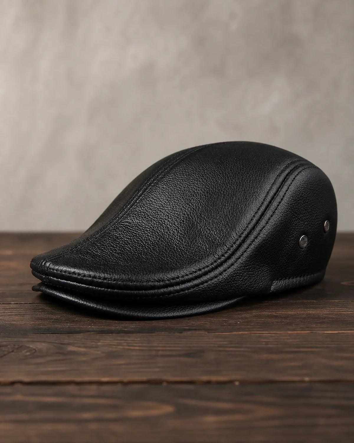 Boina Masculina Inglesa de Couro Dorian Black sobre mesa de madeira escura Cappel