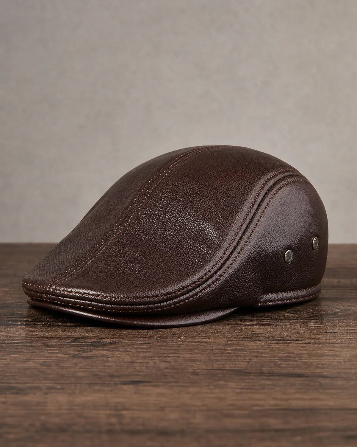 Boina Masculina Inglesa de Couro Dorian Coffee sobre mesa de madeira escura Cappel
