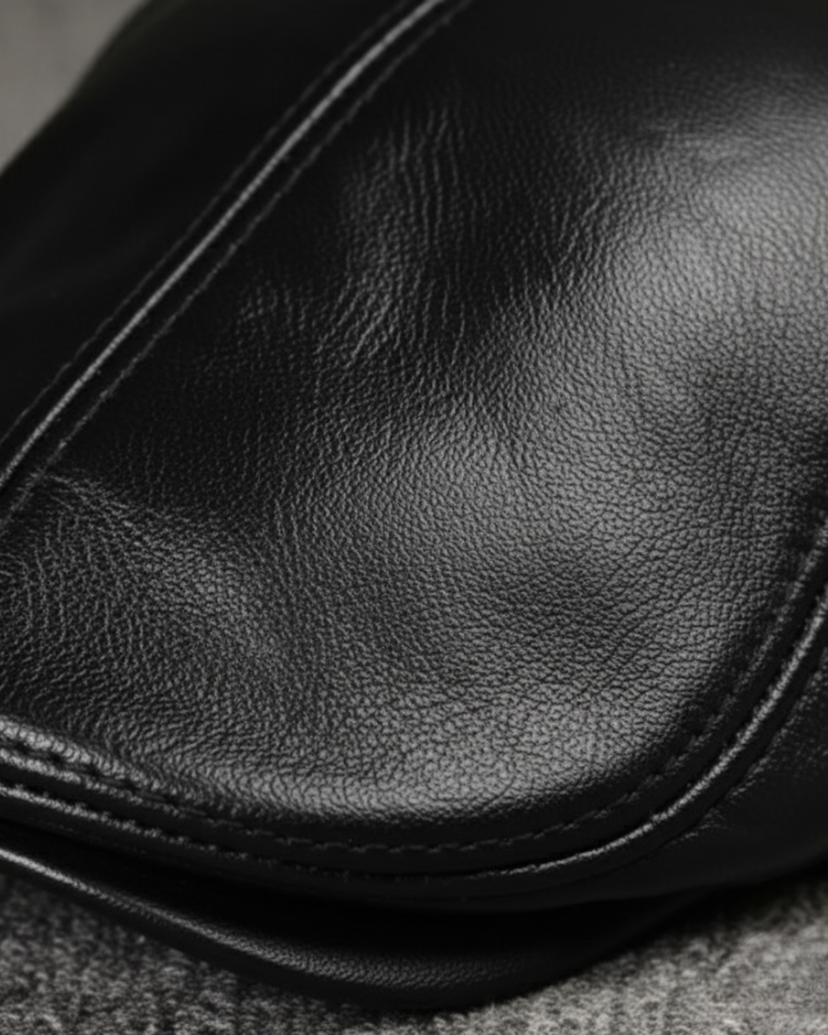 Detalhe da textura do couro legítimo preto, costura reforçada e acabamento premium da boina masculina inglesa Dorian Black