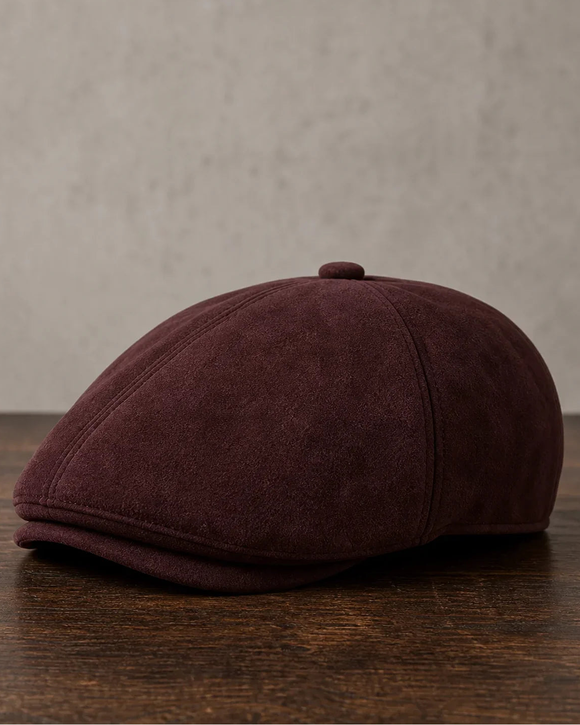 Boina Masculina Inglesa Couro Vegan Burgundy sobre mesa de madeira escura Cappel