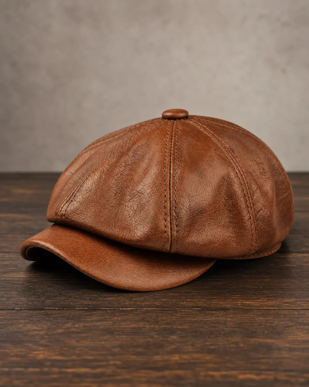Boina Masculina Italiana Couro Genuíno Brown Cappel em foto hero sobre mesa de madeira escura