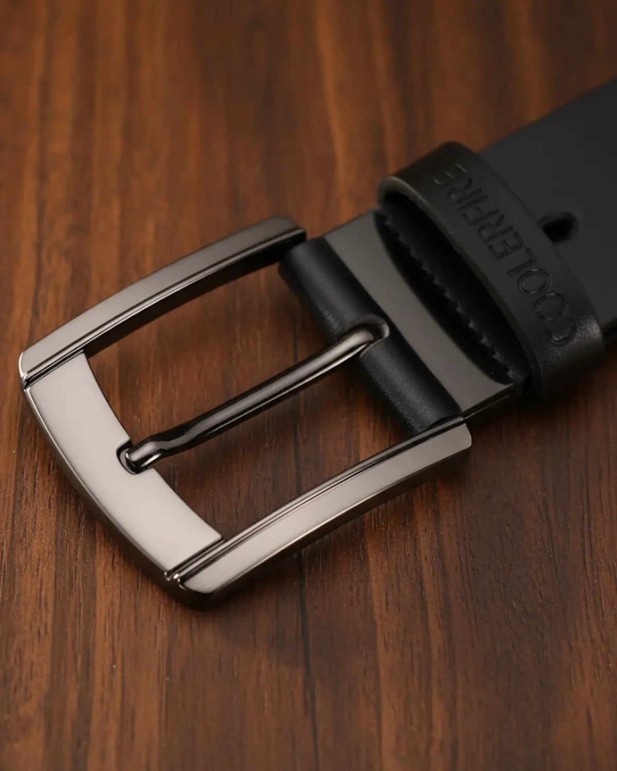 Detalhe da fivela escovada do Cinto Masculino Couro Legítimo Black Ashford sobre mesa de madeira