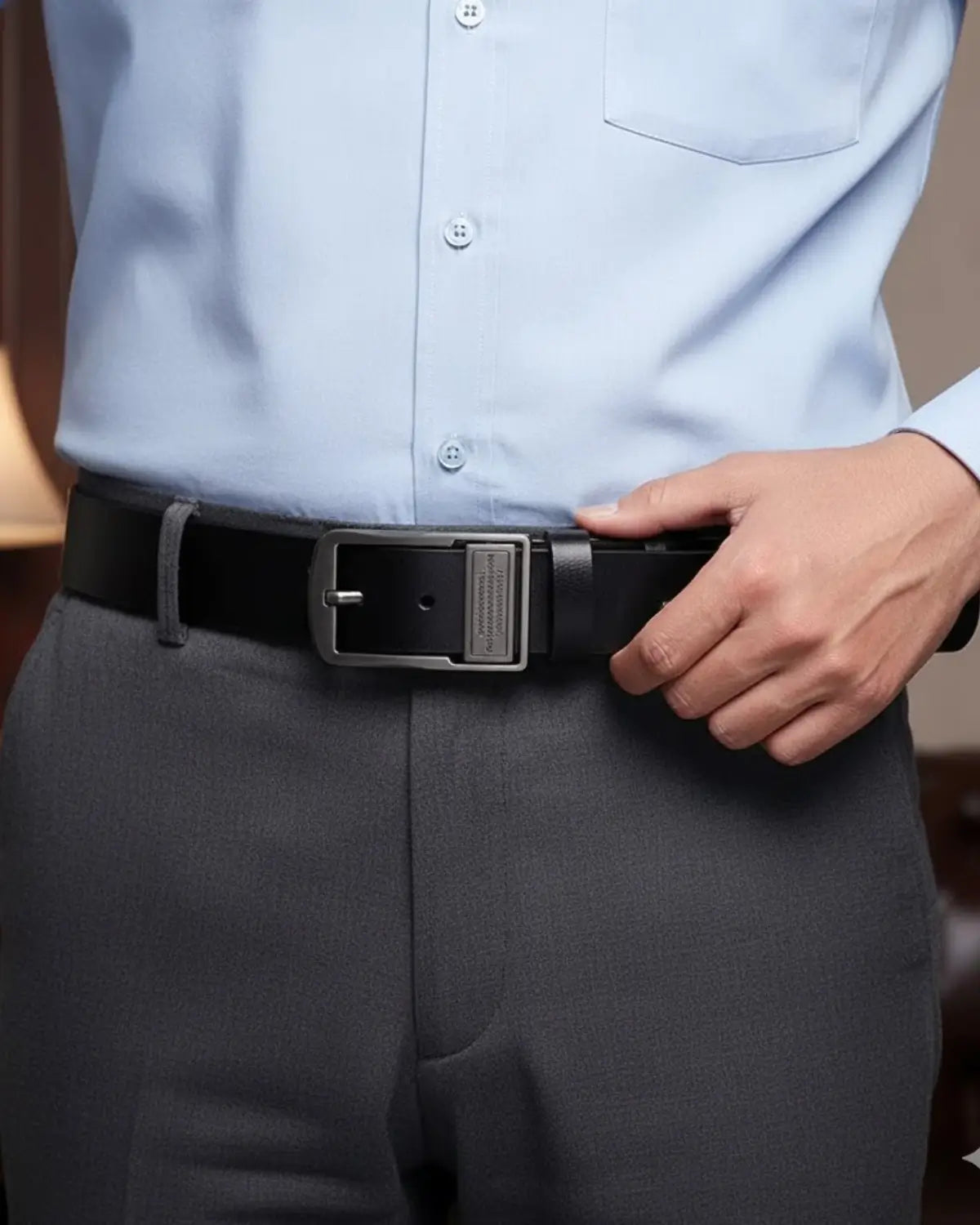 Homem ajustando o Cinto Masculino Couro Legítimo Black Royal com camisa azul clara — elegância discreta e sofisticação cotidiana