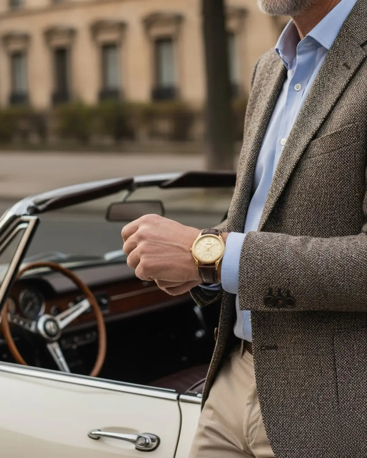 Homem de barba grisalha usando Relógio monarch Gold próximo a carro conversível clássico — sofisticação e lifestyle europeu