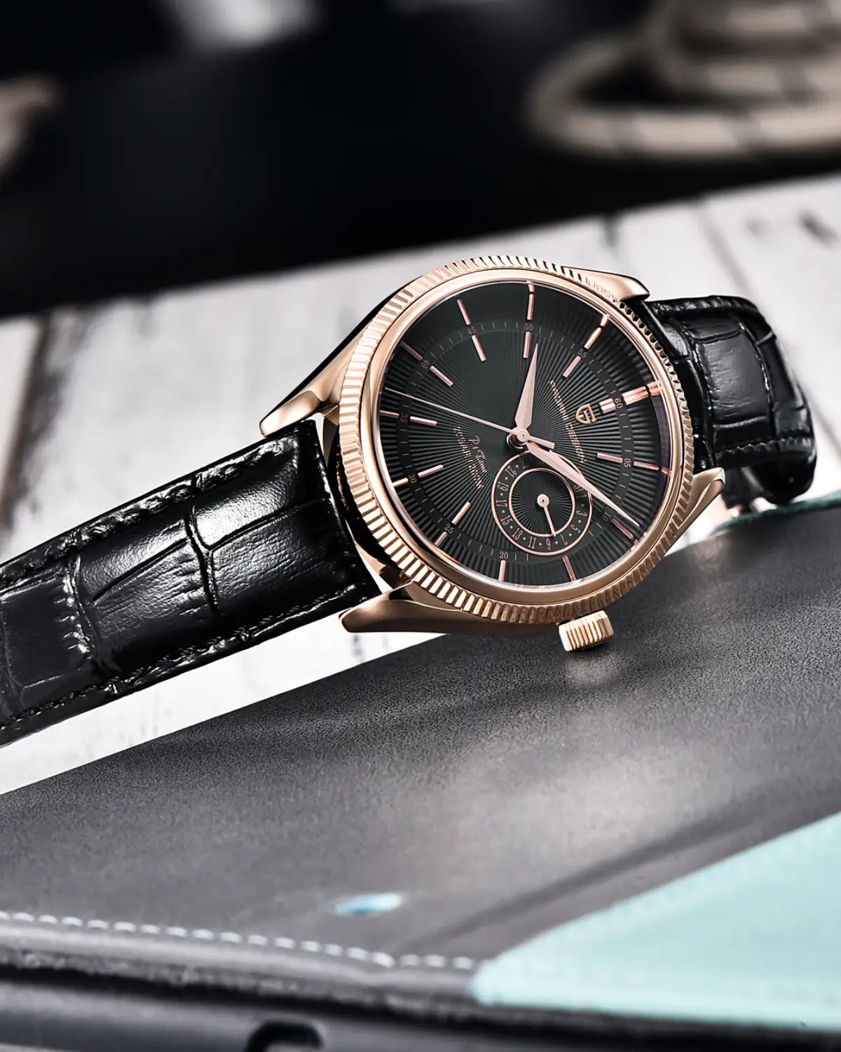 Relógio Masculino Pulseira de Couro Regent Black Gold apoiado sobre mesa de madeira escura