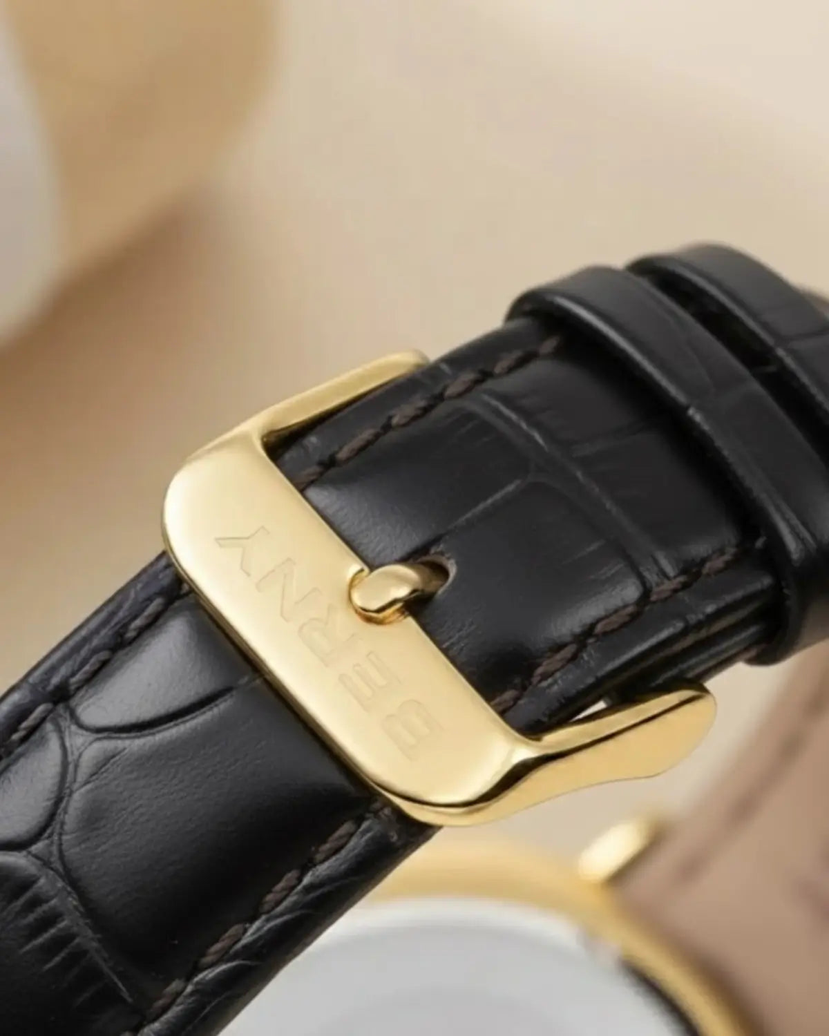 Detalhe da fivela dourada com gravação Berny no relógio Monarch Black